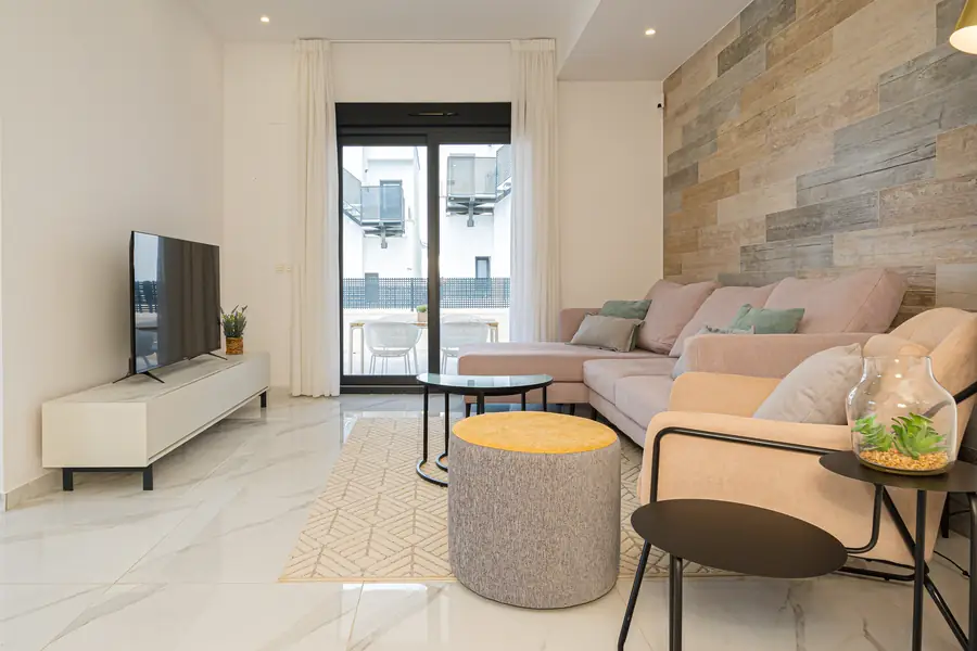 De woonkamer met loungebank en natuurstenen wand