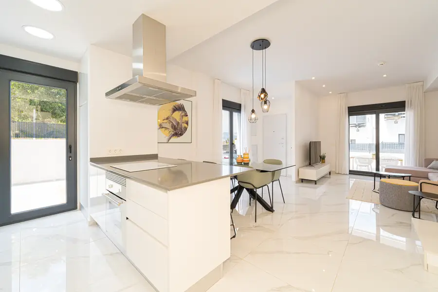 De open keuken met kookeiland en eettafel